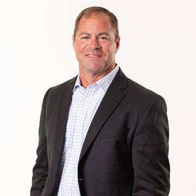 Man in a black suit jacket with a white checked shirt.