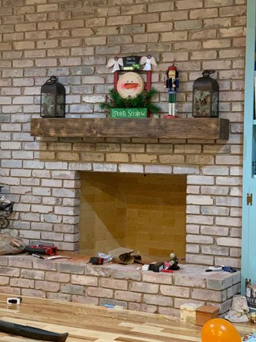 Rustic fireplace mantel on a brick fireplace