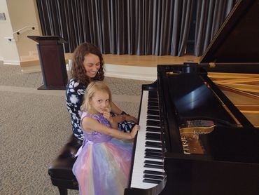 Woman teaching child piano notes