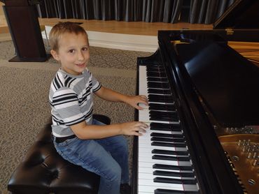 Boy playing piano in music class