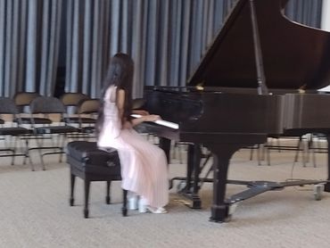 Teen playing piano in living room