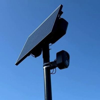 Solar panel mounted on a pole against a clear blue sky.