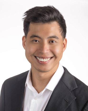 Smiling man in business attire against a white background.