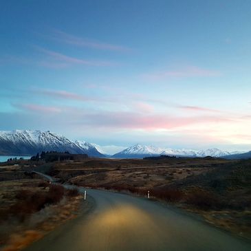 early morning sunrise, driving down the road, snowy mountains