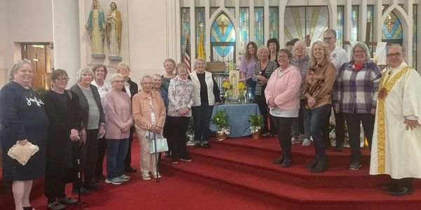 Group photo of people inside a church standing near the altar.