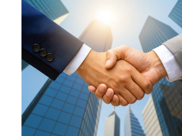 Two people in suits shaking hands, symbolizing agreement.