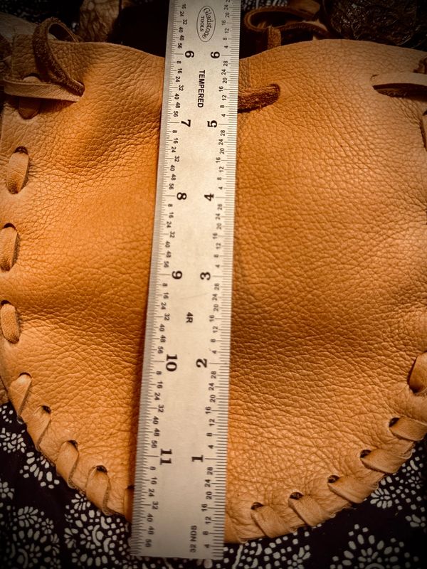 Leather pouch with ruler measuring its length.