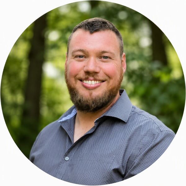Smiling man with beard outdoors.