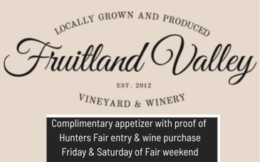 Promotional sign for Fruitland Valley vineyard offering a complimentary appetizer with wine purchase.