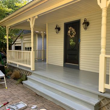 Freshly painted porch and steps on a house with beige siding.
