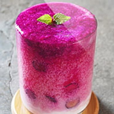 Pink fizzy juice with leaf on top in sun