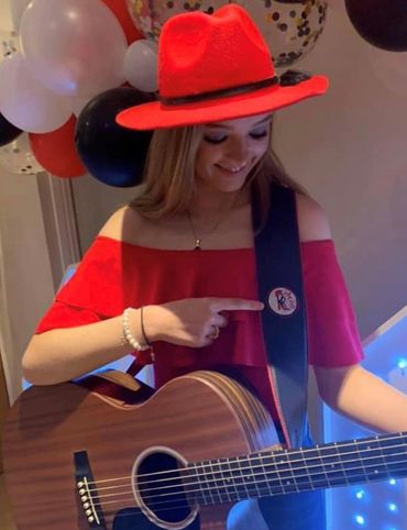 Female guitar is, Robyn red, with a acoustic guitar with leather guitar strap attached. 