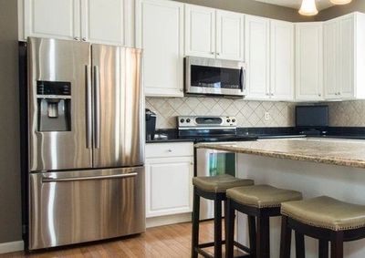 Refrigerator connected to plumbing water supply to deliver ice cubes and cold, filtered water straight out of the fridge 