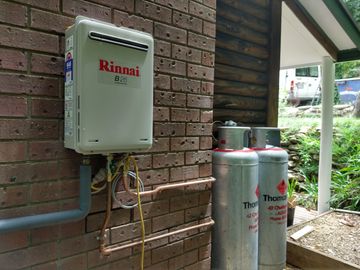 LPG gas cylinder installation and a Rinnai instant gas hot water system. Instant hot water on demand powered by clean burning LPG gas. 