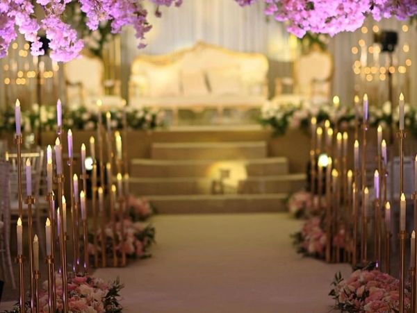 walkway into venue with candle sticks and half moon blossom trees