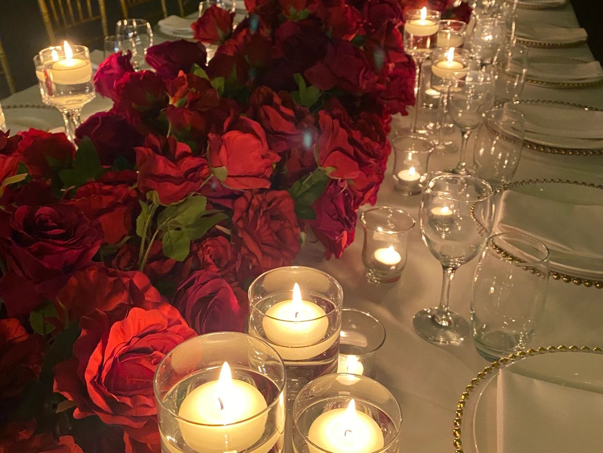 red rose runner on table with glasswear and candles