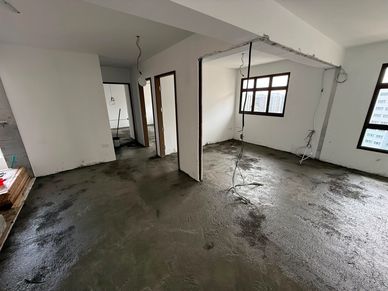 Empty room under construction with wet cement floor.