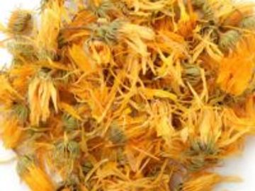 Dried vibrant orange calendula flowers with green centers.
