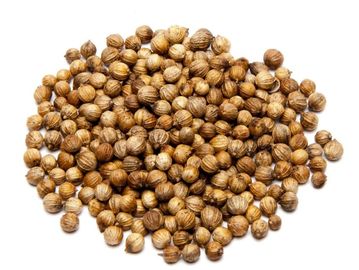 Pile of coriander seeds on a white background.