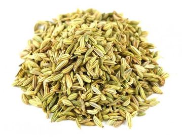 A pile of dried fennel seeds on a white background.