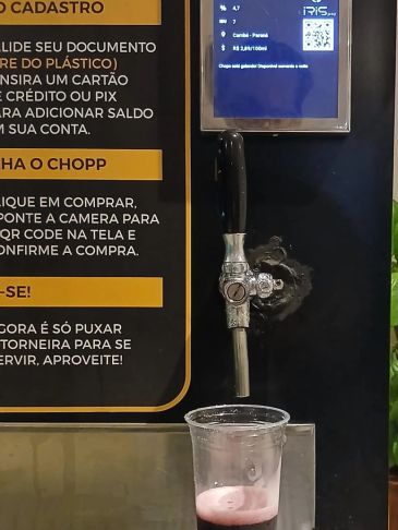 Maquina de chopp com caneca e instruções em português.