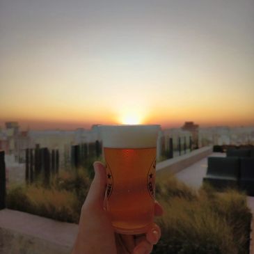 Copo de cerveja ao pôr do sol.