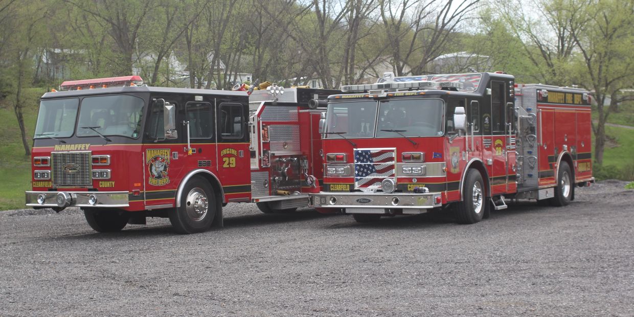 Two red fire trucks parked side by side.