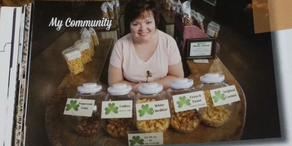Image of CEO/founder Tonya Burton surrounded by Carmel Yum Yums from a magazine