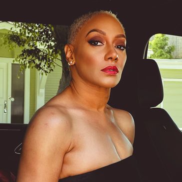 Tangela Levinson seated in a black strapless gown inside a black SUV with quiet power and  poise.