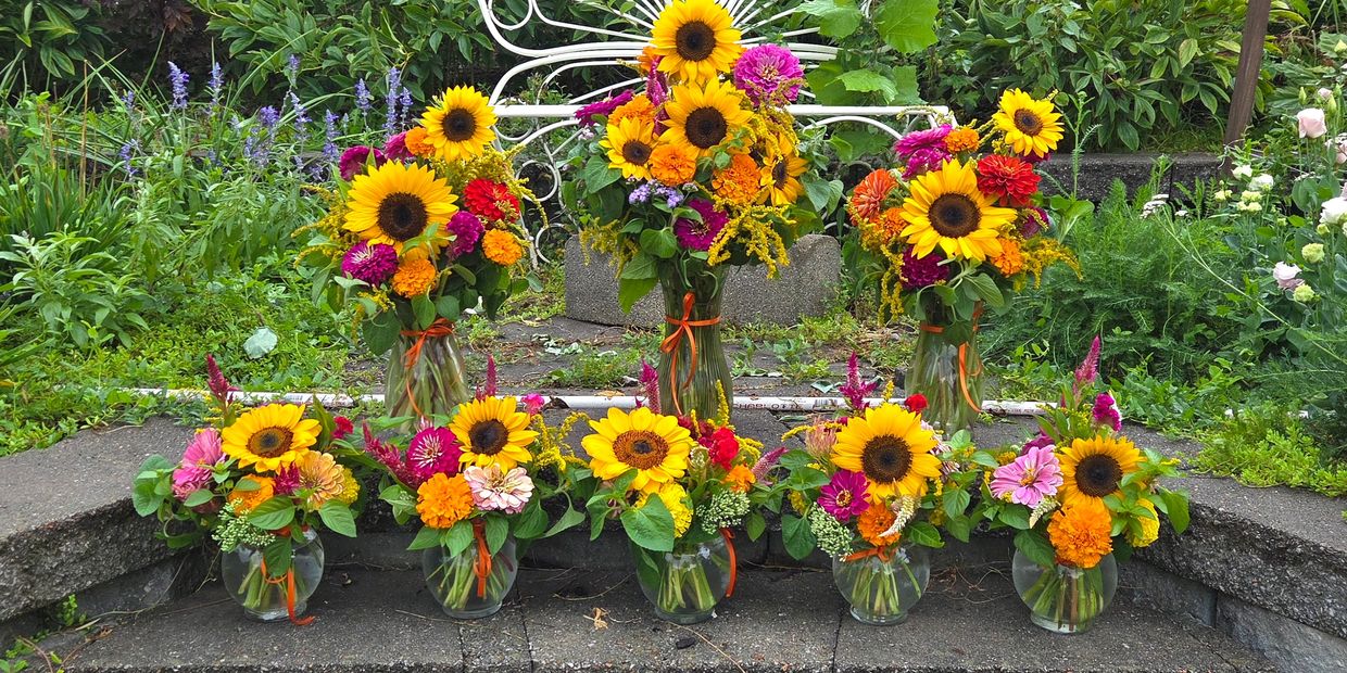 Bright sunflower and colorful flower bouquets in vases.