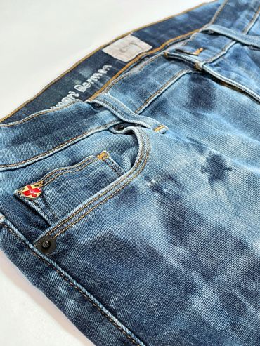Close up of the right front pocket on a pair of bleached, UpCycled denim jeans.