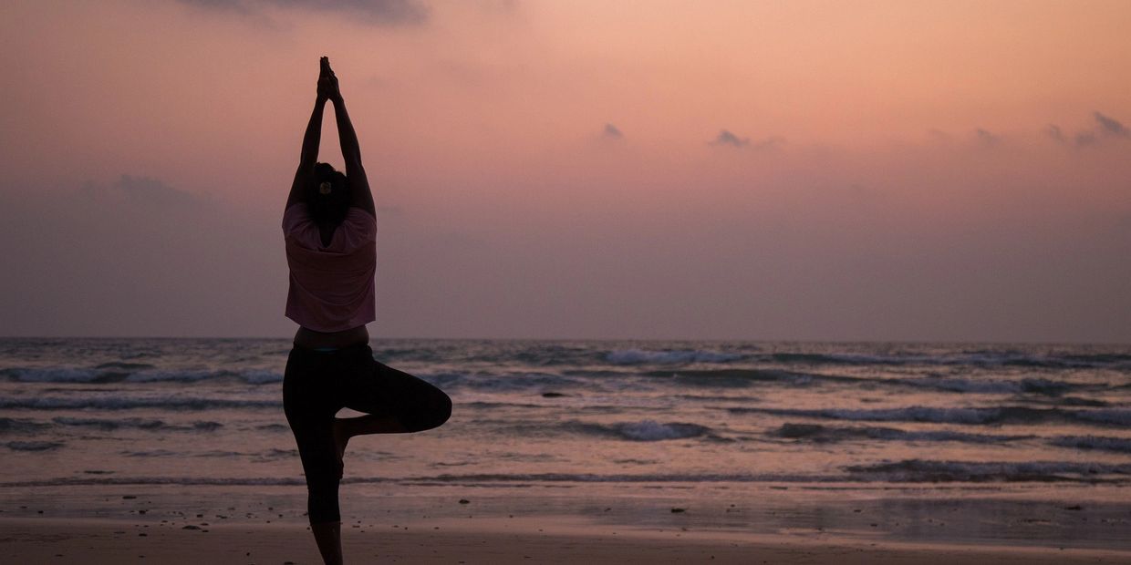 Yoga Pose on the beach with the sun setting