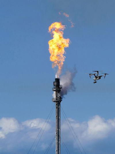 Drone inspecting a live flare stack