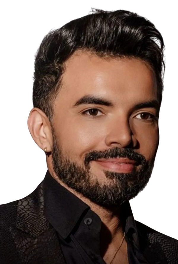 Portrait of a man with a beard and styled hair, smiling gently.