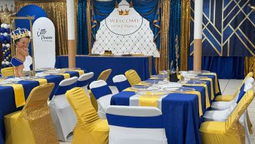 Elegant royal-themed party setup with blue, white, and gold decor.