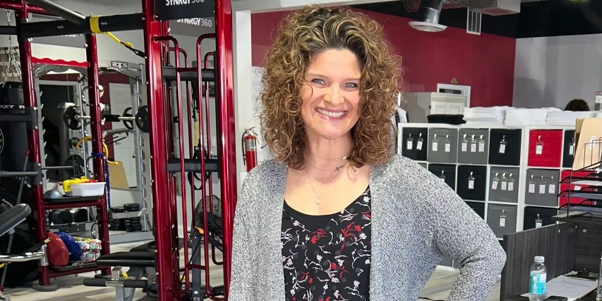 Smiling woman in workout gym setting.