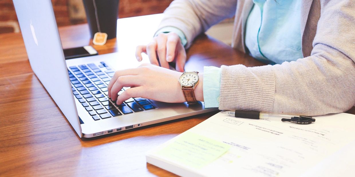 Person typing on a laptop at a desk.