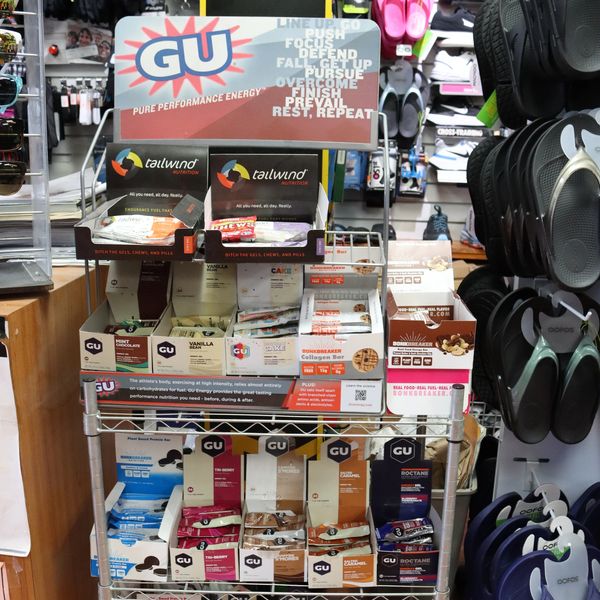 Energy gels and nutrition bars display for athletes in a sports store.