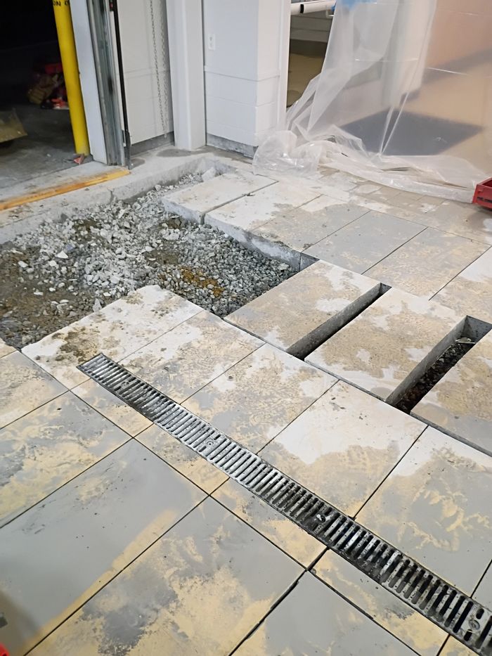 Sections cut out of a concrete floor next to a trench drain