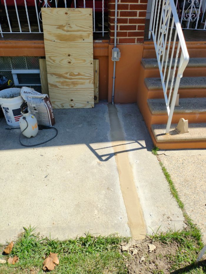 Concrete slab beside porch steps with the joint filled