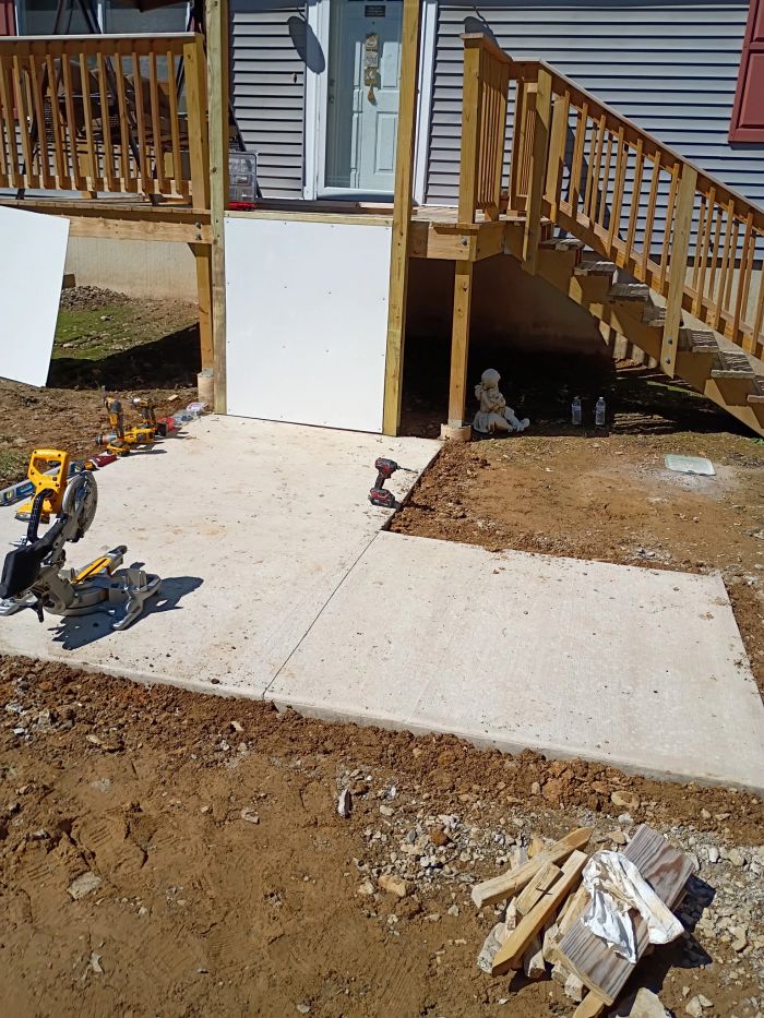 New concrete pad at the bottom of deck stairs