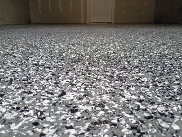 Garage floor with a gray, black and white flake finish, seen from floor level