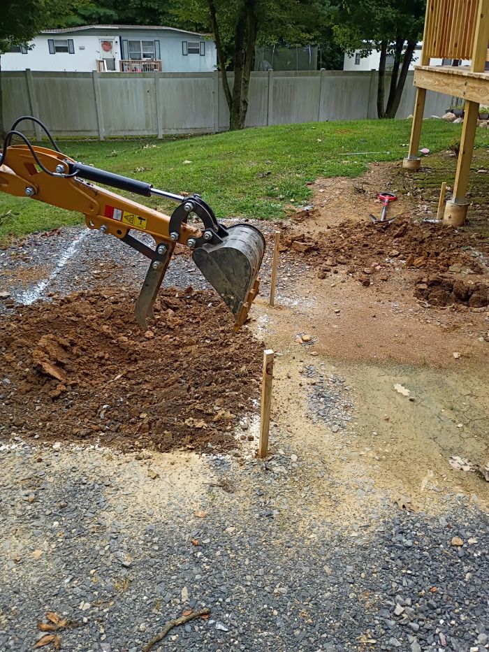 Small excavator digging in a yard