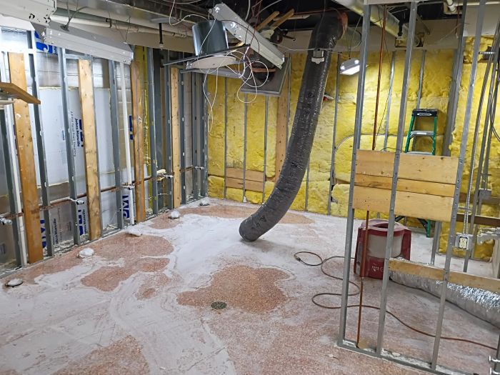 Framed interior under construction with old residue on the concrete floor