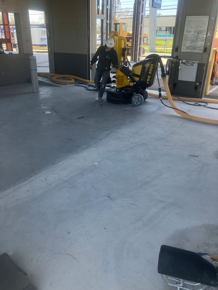 Floor grinder and vacuum hoses at work in a commercial space