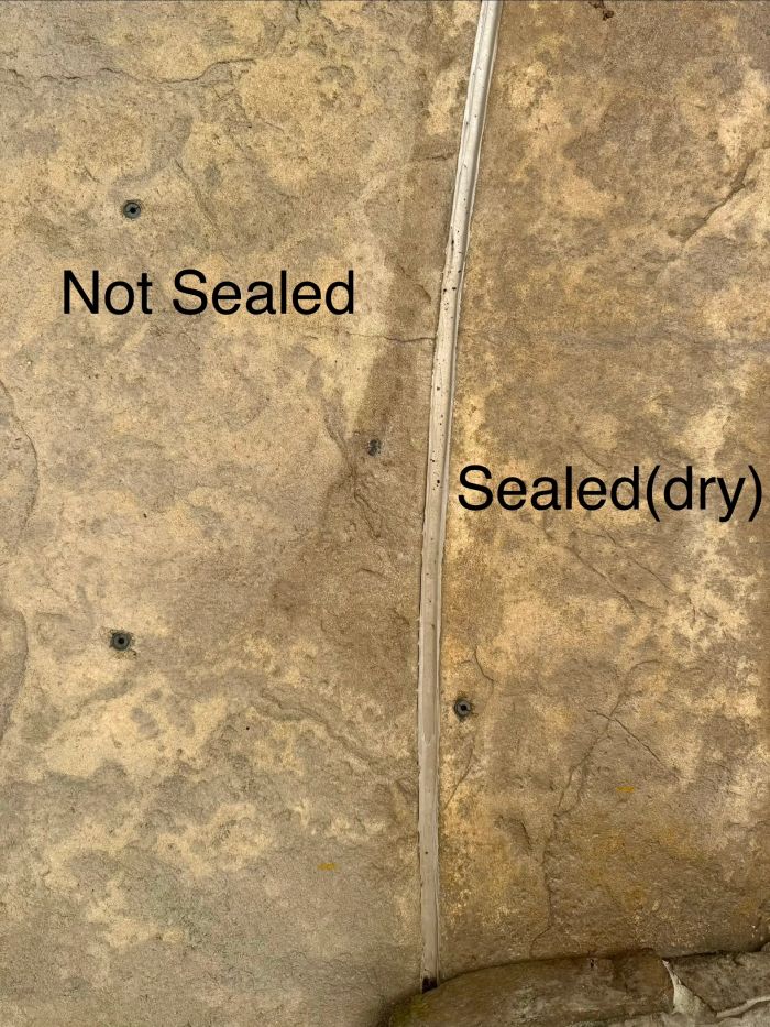 Stamped concrete labeled not sealed on one side and sealed on the other
