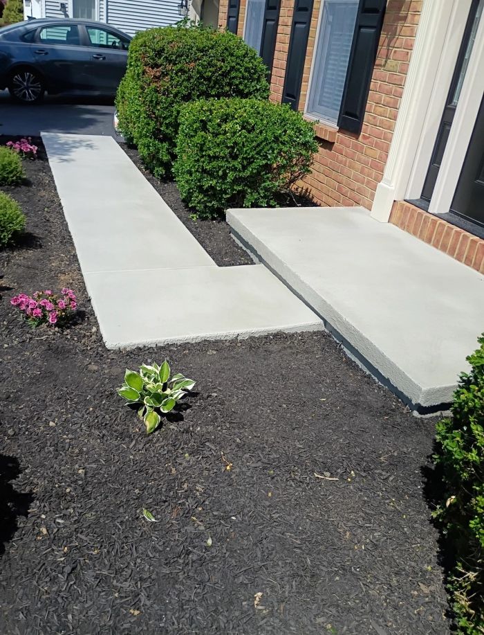 Concrete walkway and landing beside a brick house