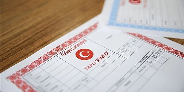 A Turkish property deed document on a wooden table.