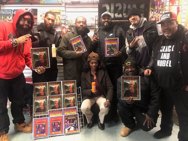 Group of people holding magazines and a bottle indoors.
