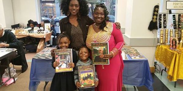 Four people holding books and smiling at a book event.